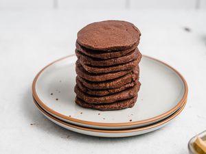 Tender chocolate butter cookies stacked on a ceramic plate.