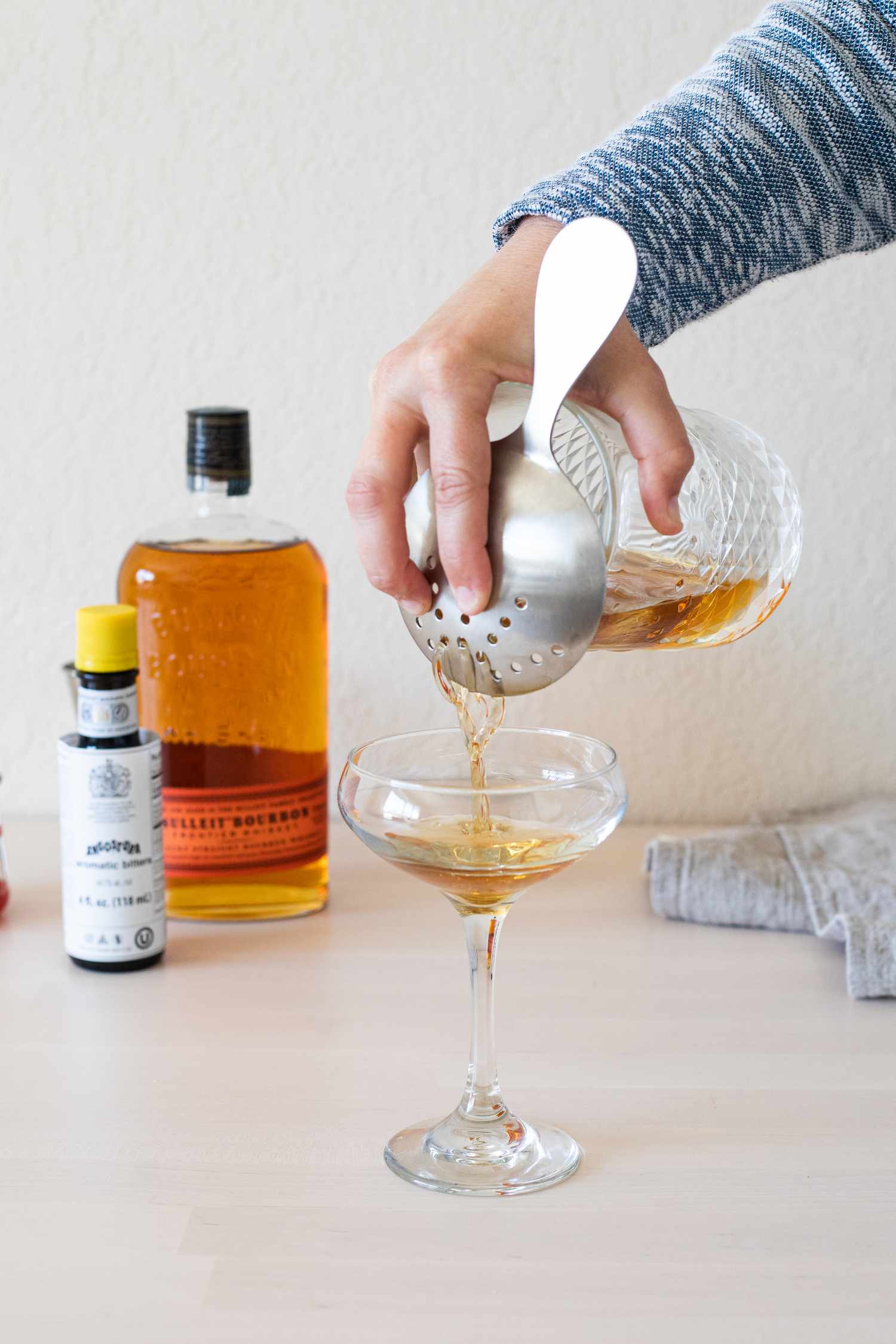Pouring a cocktail into a coupe glass