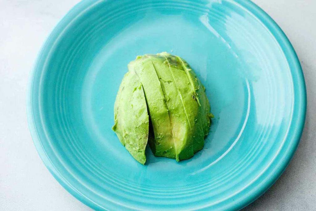 Sliced avocado on a blue plate for air fryer avocado fries