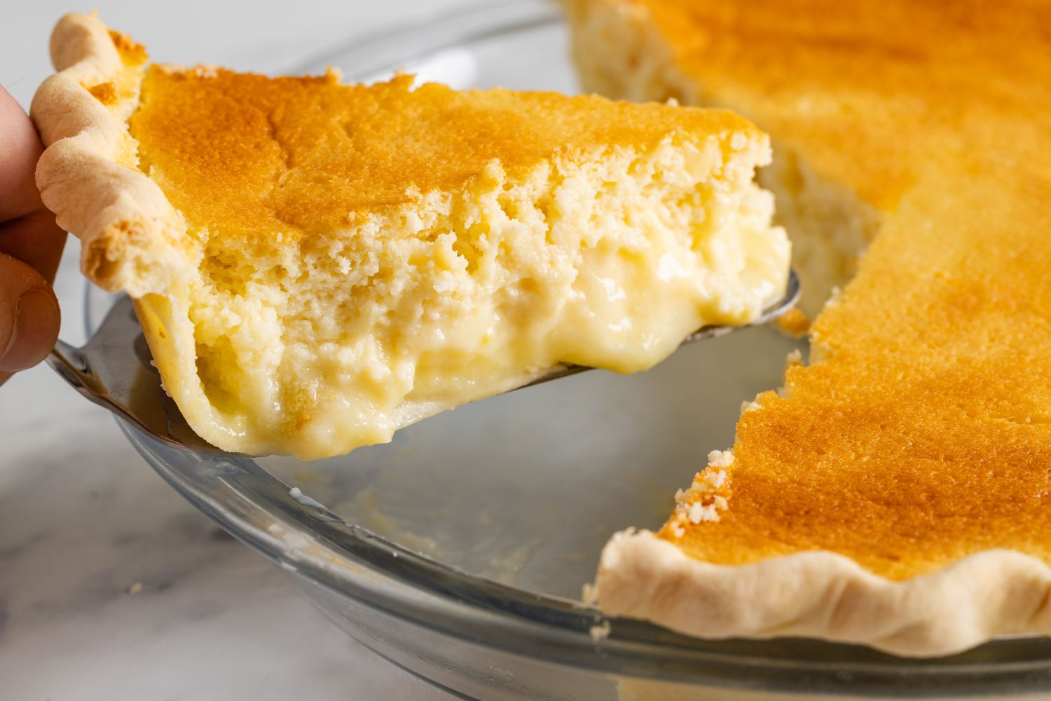 A slice of lemon pie being lifted from a pie dish