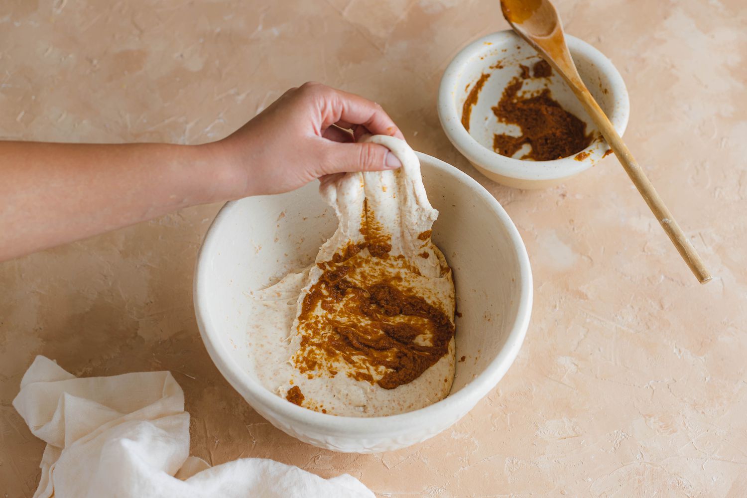 Folding spices into dough to make spiced sourdough bread shaped like a pumpkin.