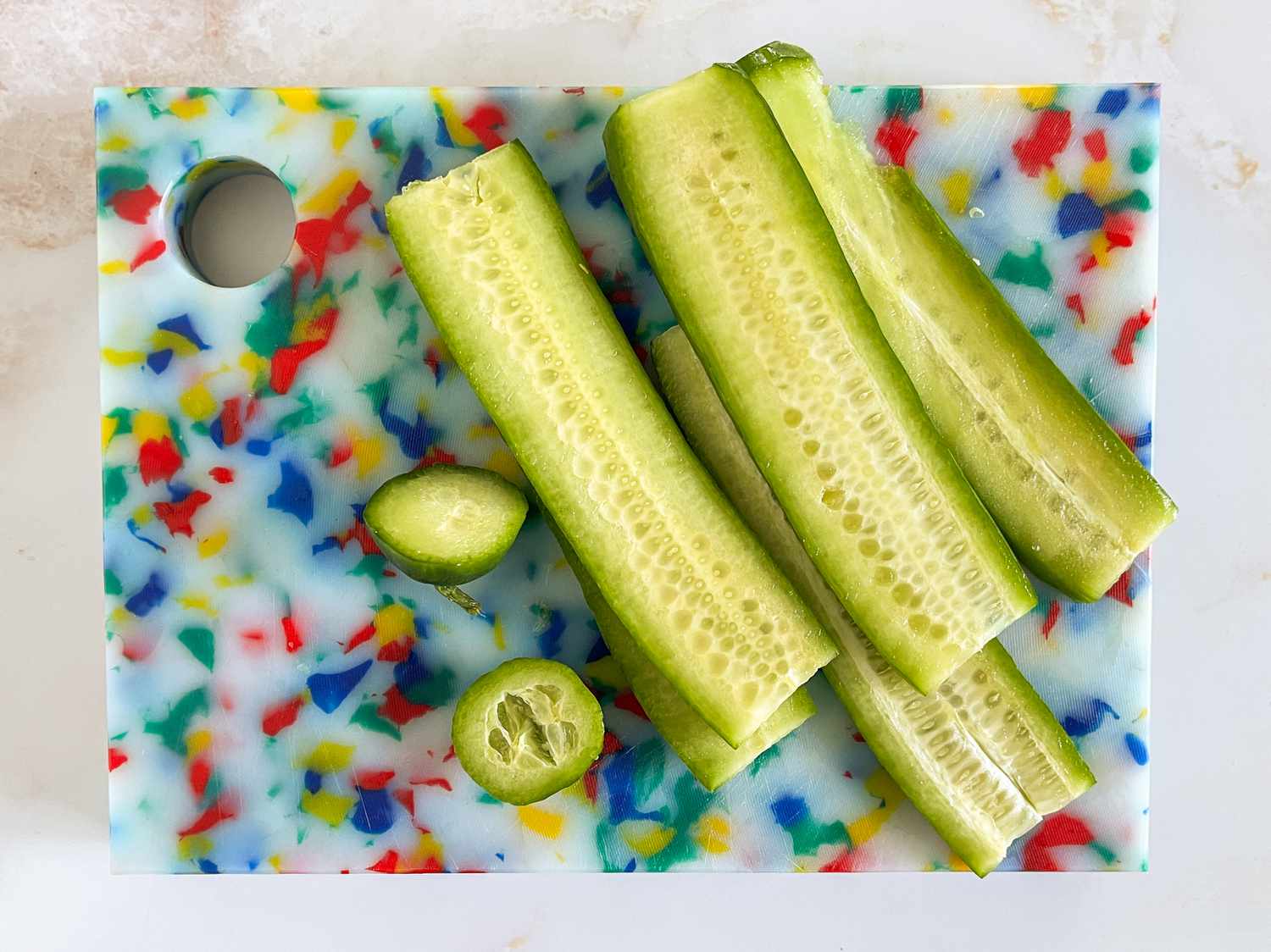 Cucumber cut into halves (lengthwise) on a cutting board