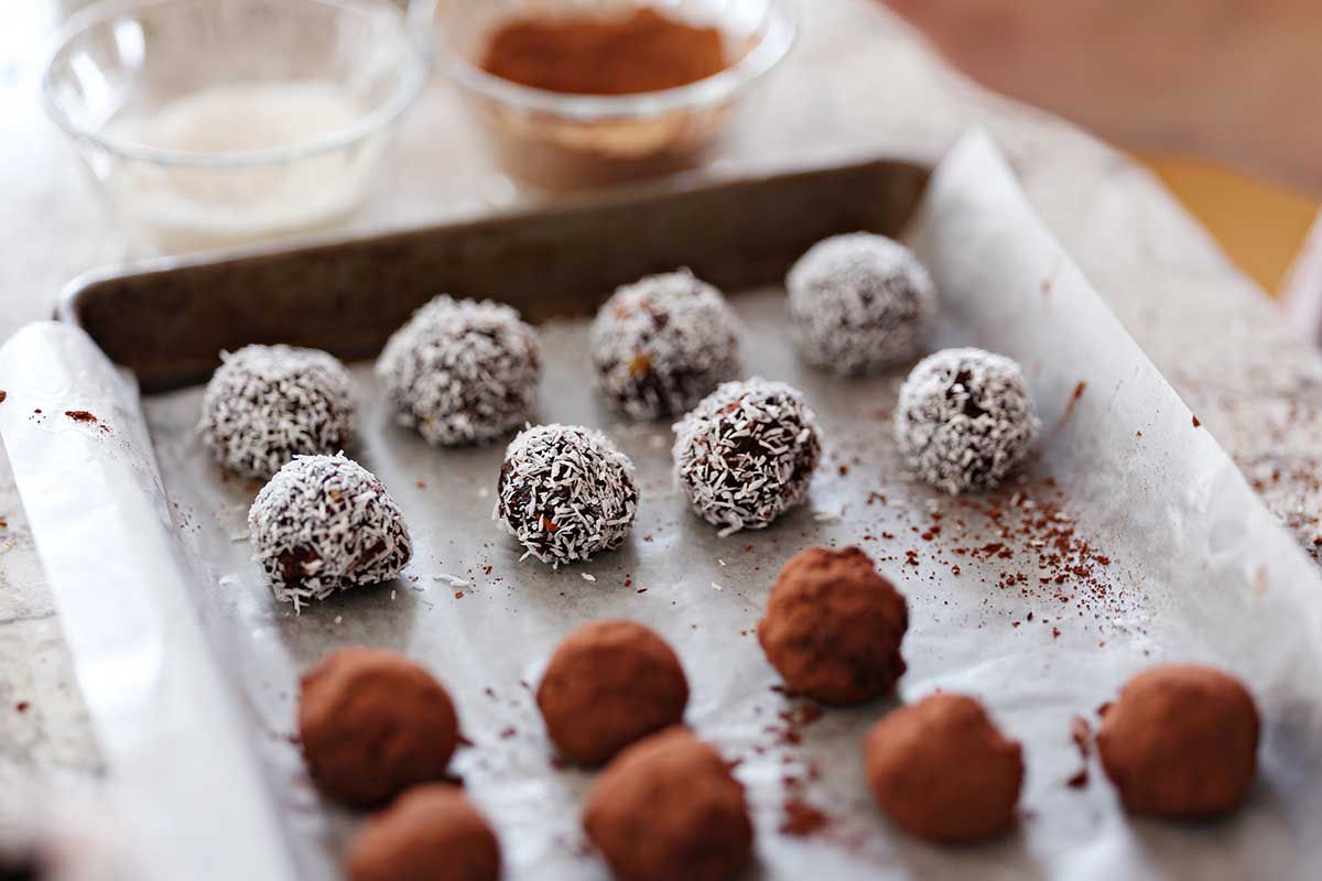 Chocolate almond butter balls line the balls on the baking sheet