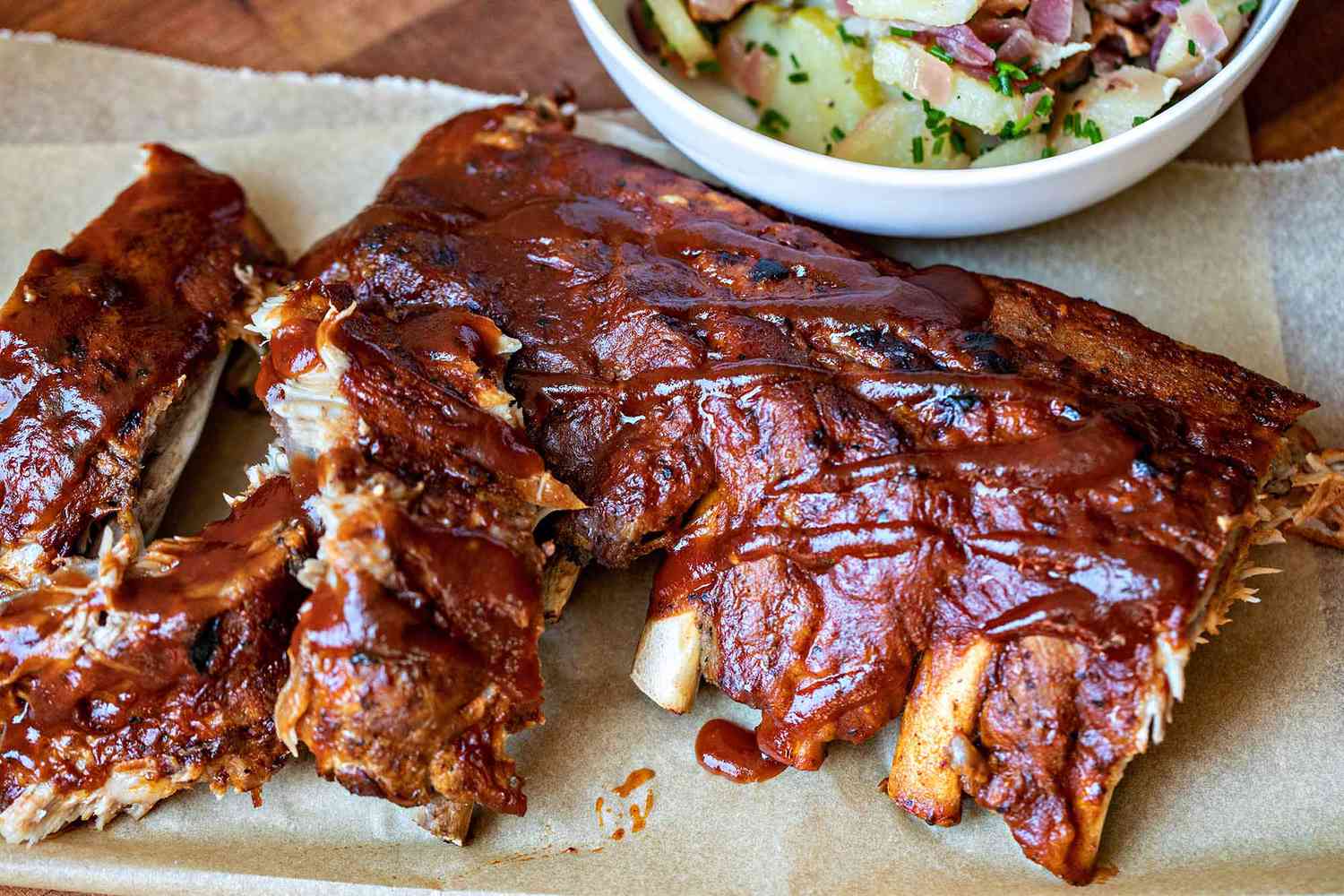 BBQ baby back ribs with side bowl of potato salad