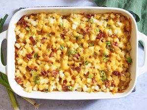 Baked casserole with diced ingredients melted cheese and garnished with green onions in a rectangular dish