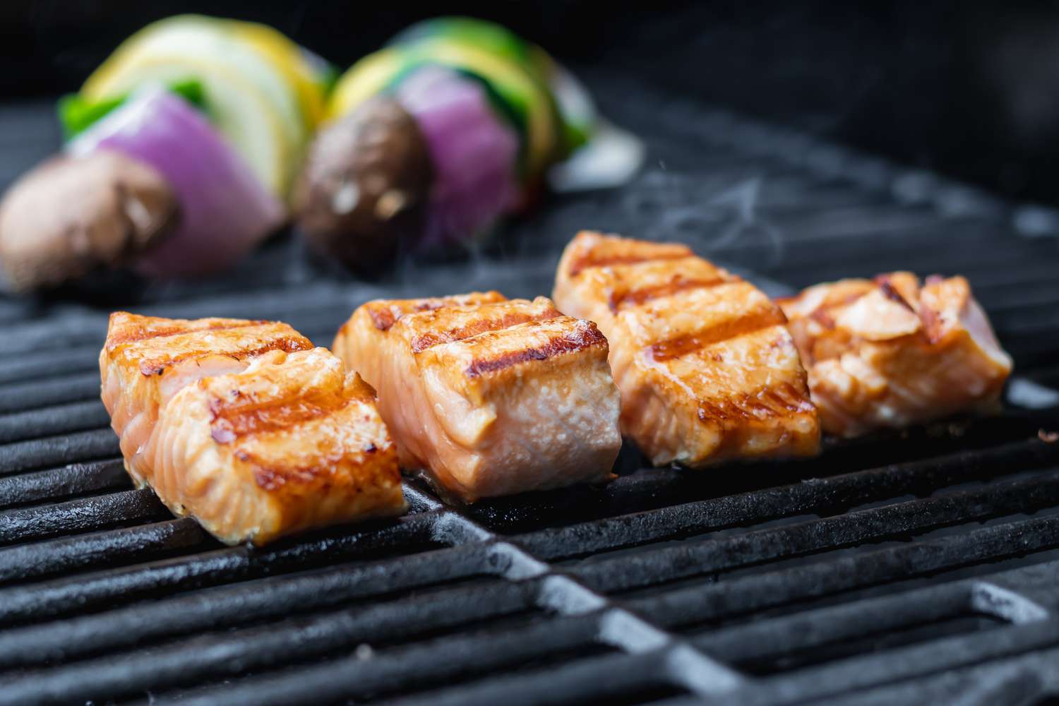 Four fillets on a grill to show how to cook salmon.