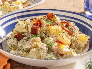bowl of ranch potato salad, and in the background, a platter wtih more and a glass of water