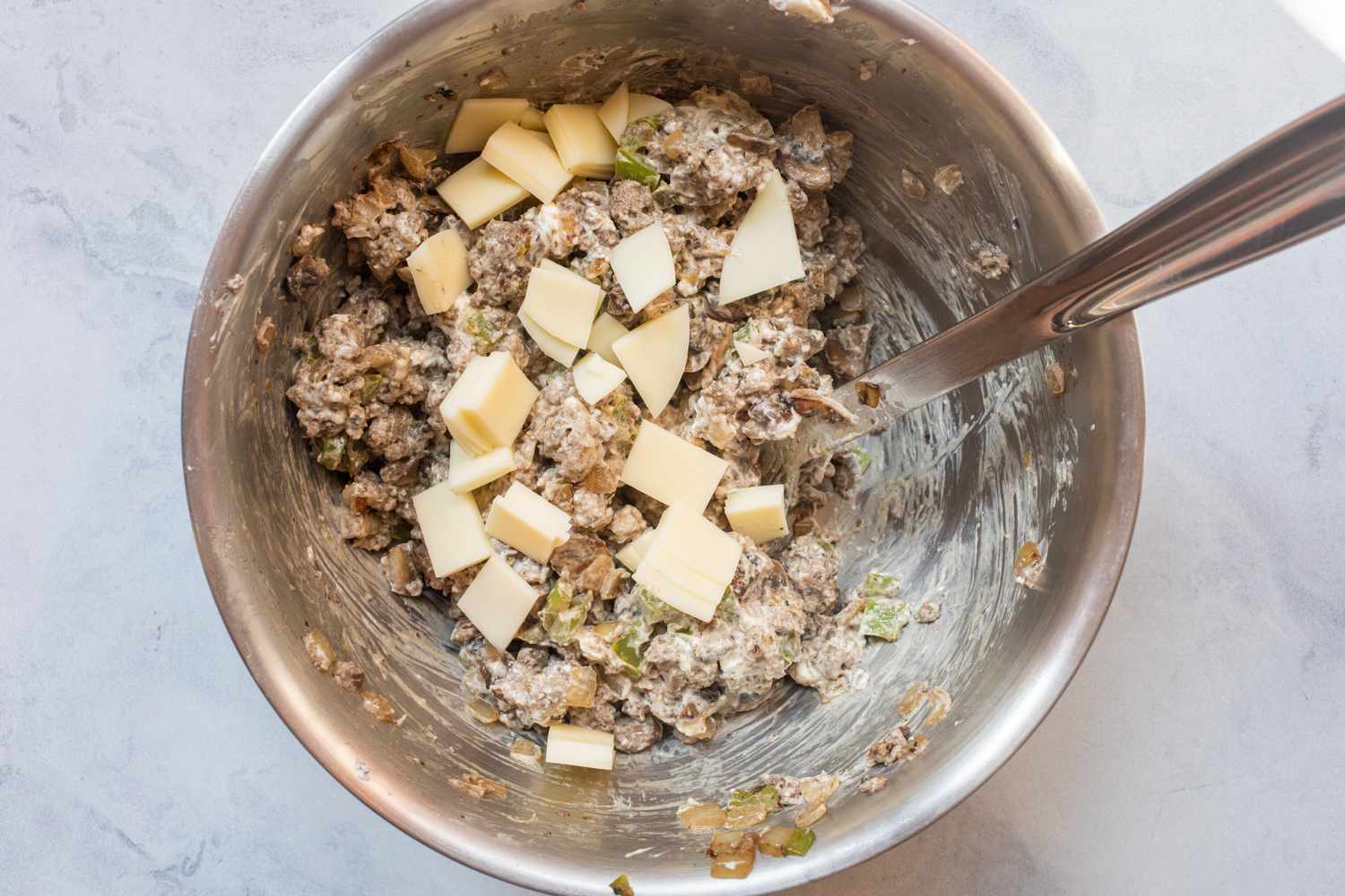 Philly cheesesteak casserole mixture in bowl.