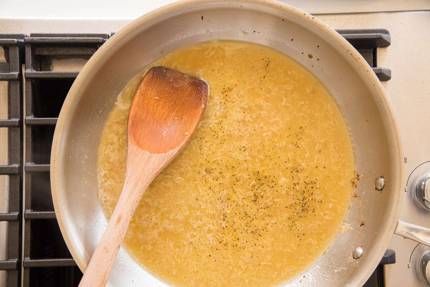 Chicken Stock and Seasoning Added to Lemon Pepper Chicken Sauce in a Pan on the Stove
