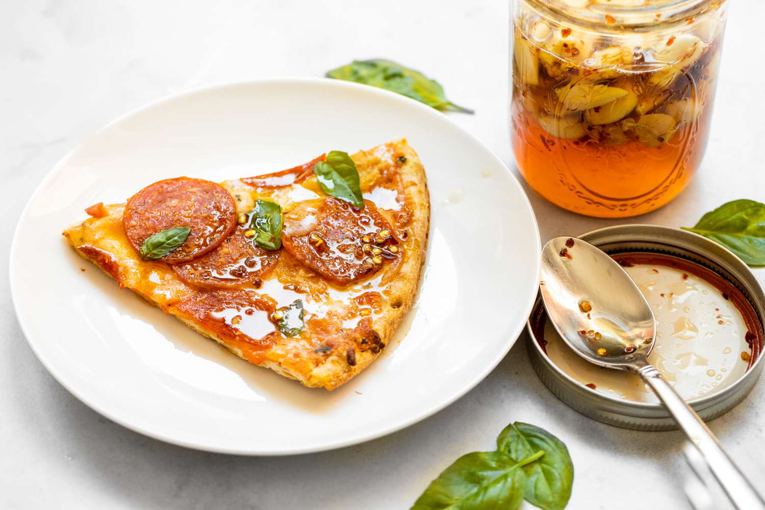 Fermented Garlic Honey on Pizza with More in the Jar in the Background