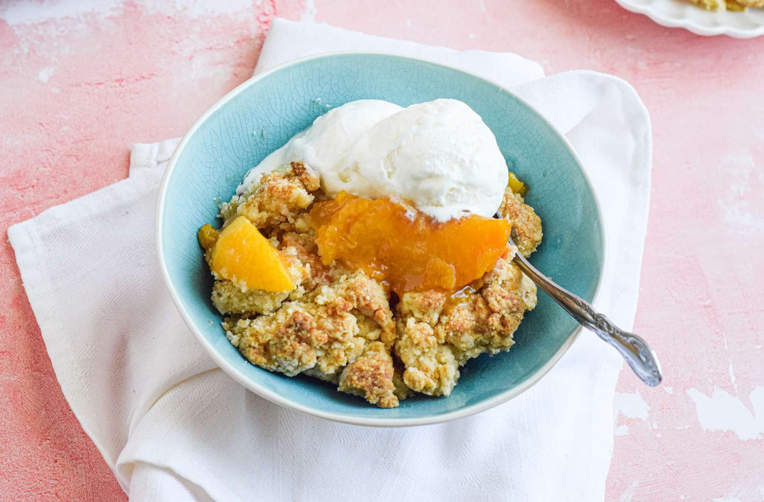 A Bowl of Peach Cobbler Topped with a Scoop of Vanilla Ice Cream