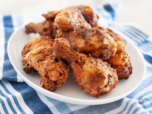 Side view of fried chicken breast stacked on a platter.