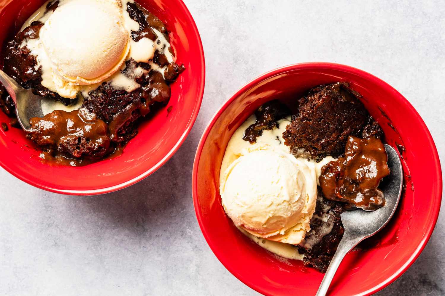 Samantha Seneviratne's 10-Minute Microwave Chocolate Pudding Cake in bowls with a scoop of ice cream and spoons