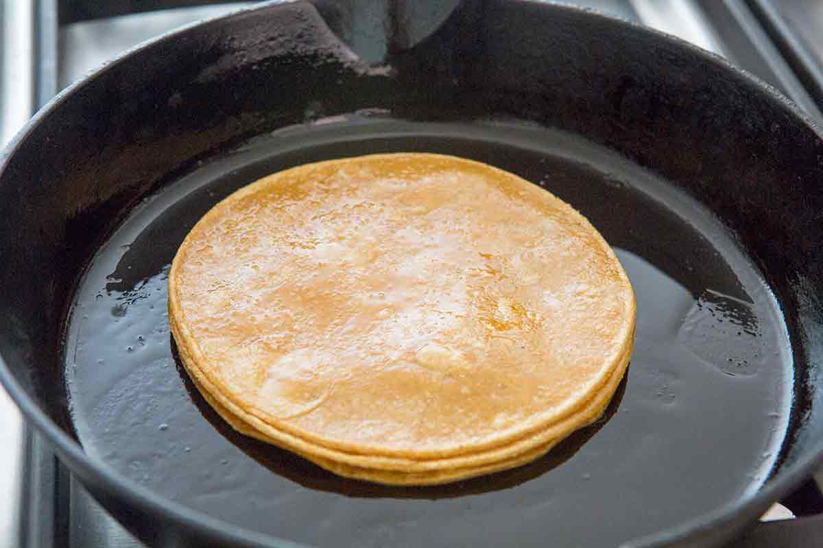 Fried Tortillas for enchiladas verdes in cooking pan