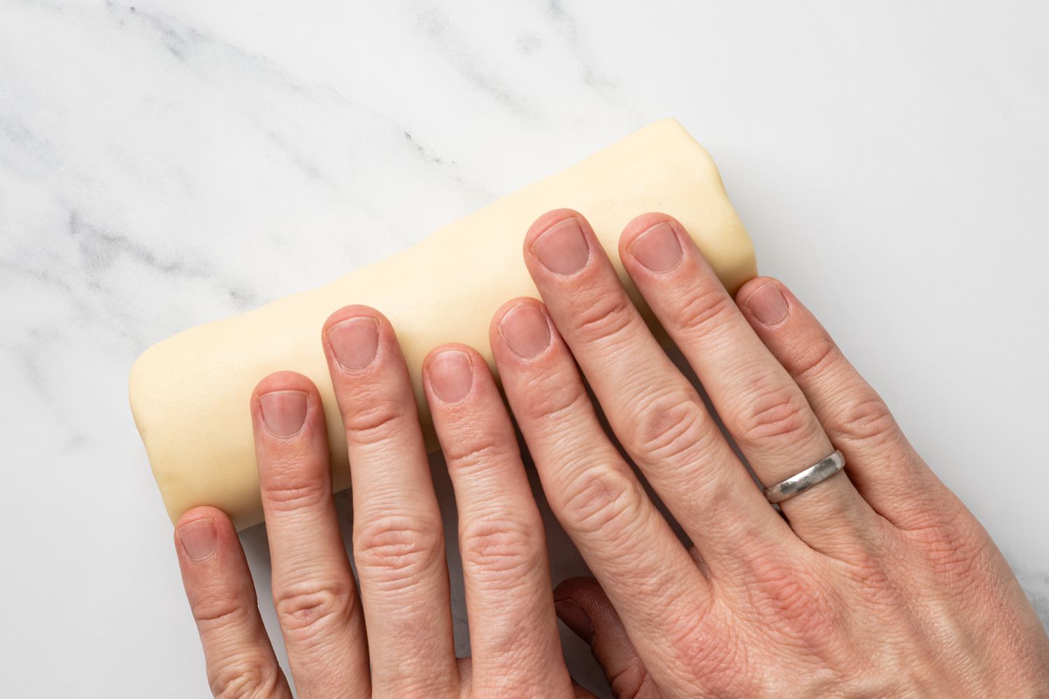 Hands Rolling Marzipan on Counter