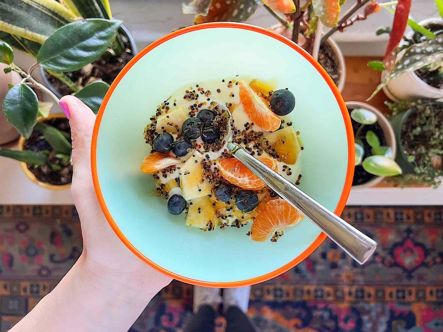 Crispy quinoa over a bowl of fruits and yogurt