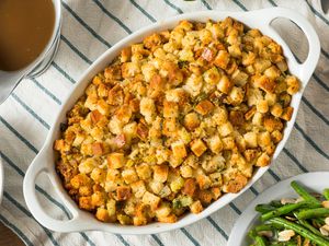 An oval white baking dish with stuffing
