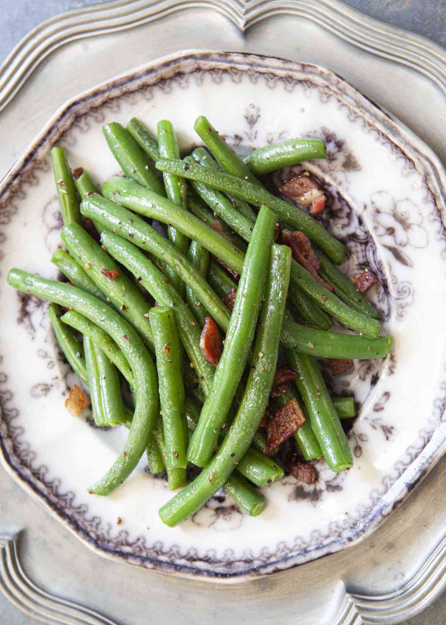 Fresh green beans cooked with bacon and served on a plate