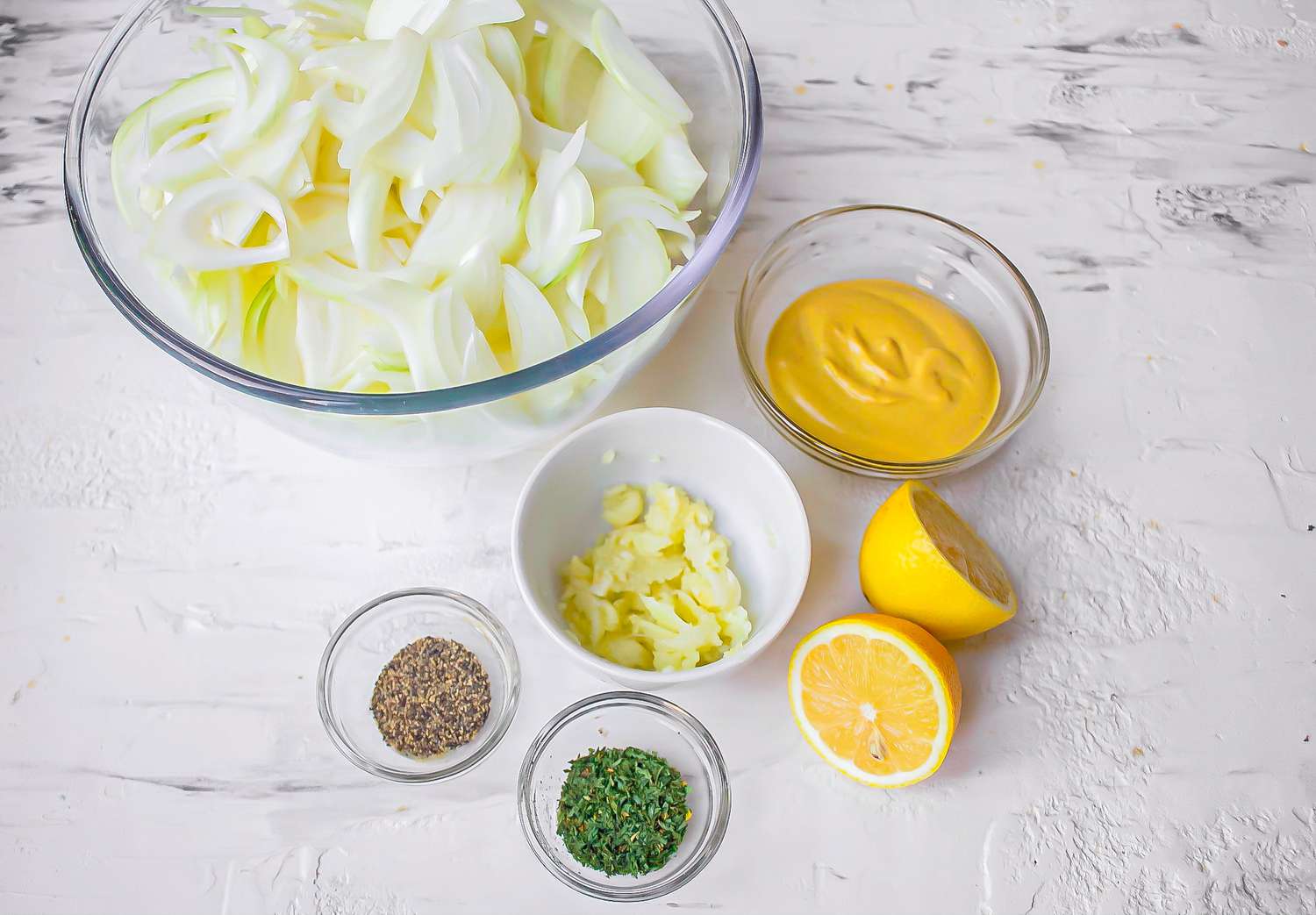 Onions in bowl with mustard, garlic and spices for chicken yassa recipe