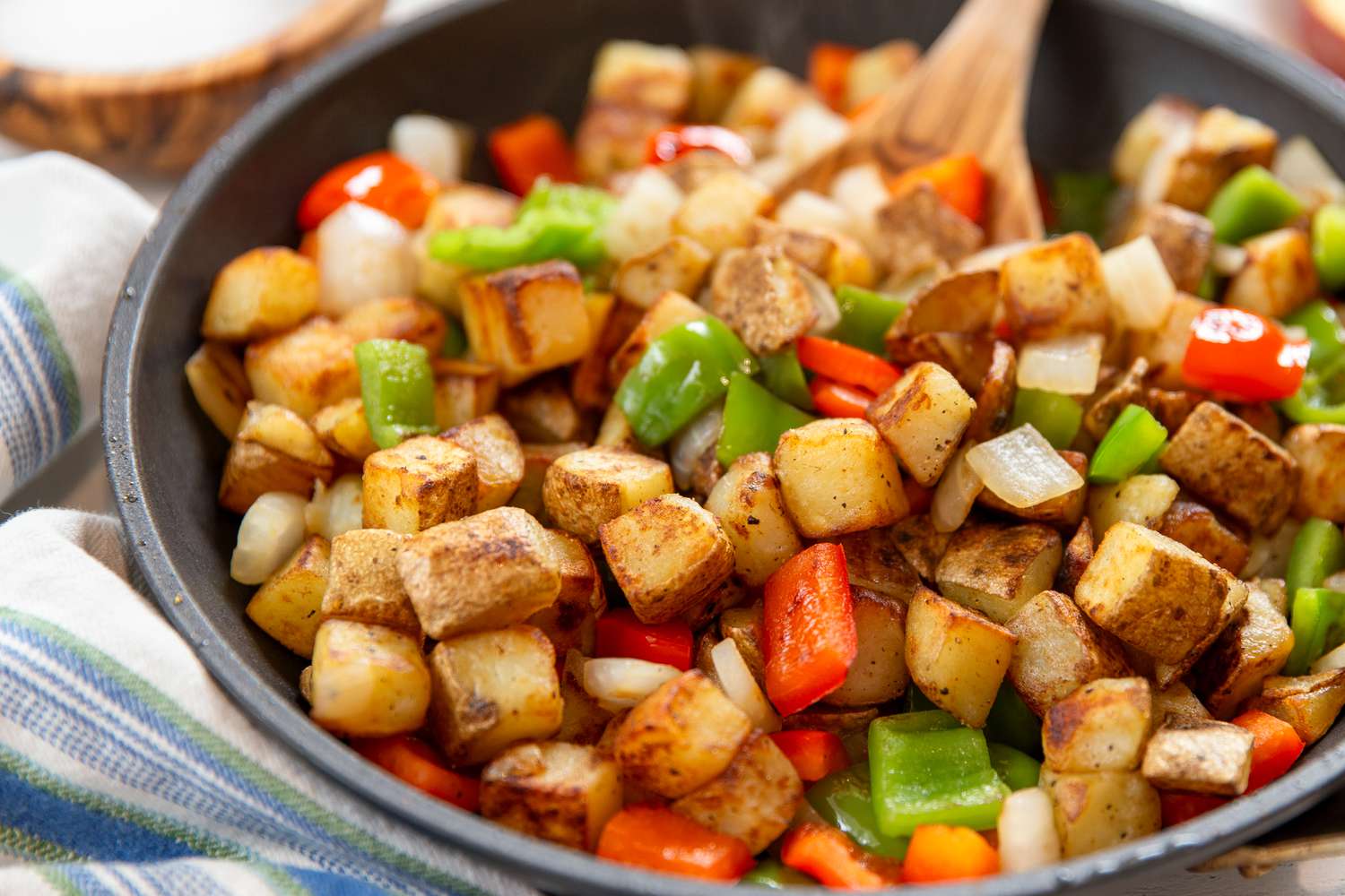 Potatoes O'Brien in a skillet at a breakfast table