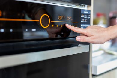 Photo of a person turning on their oven