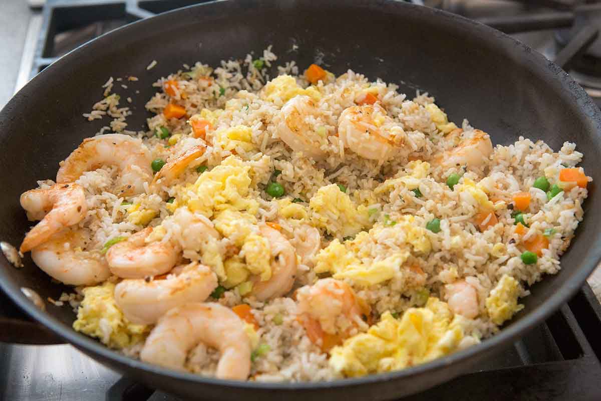 Eggs and shrimp added to rice cooking in a pan