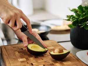 hand cutting an avocado