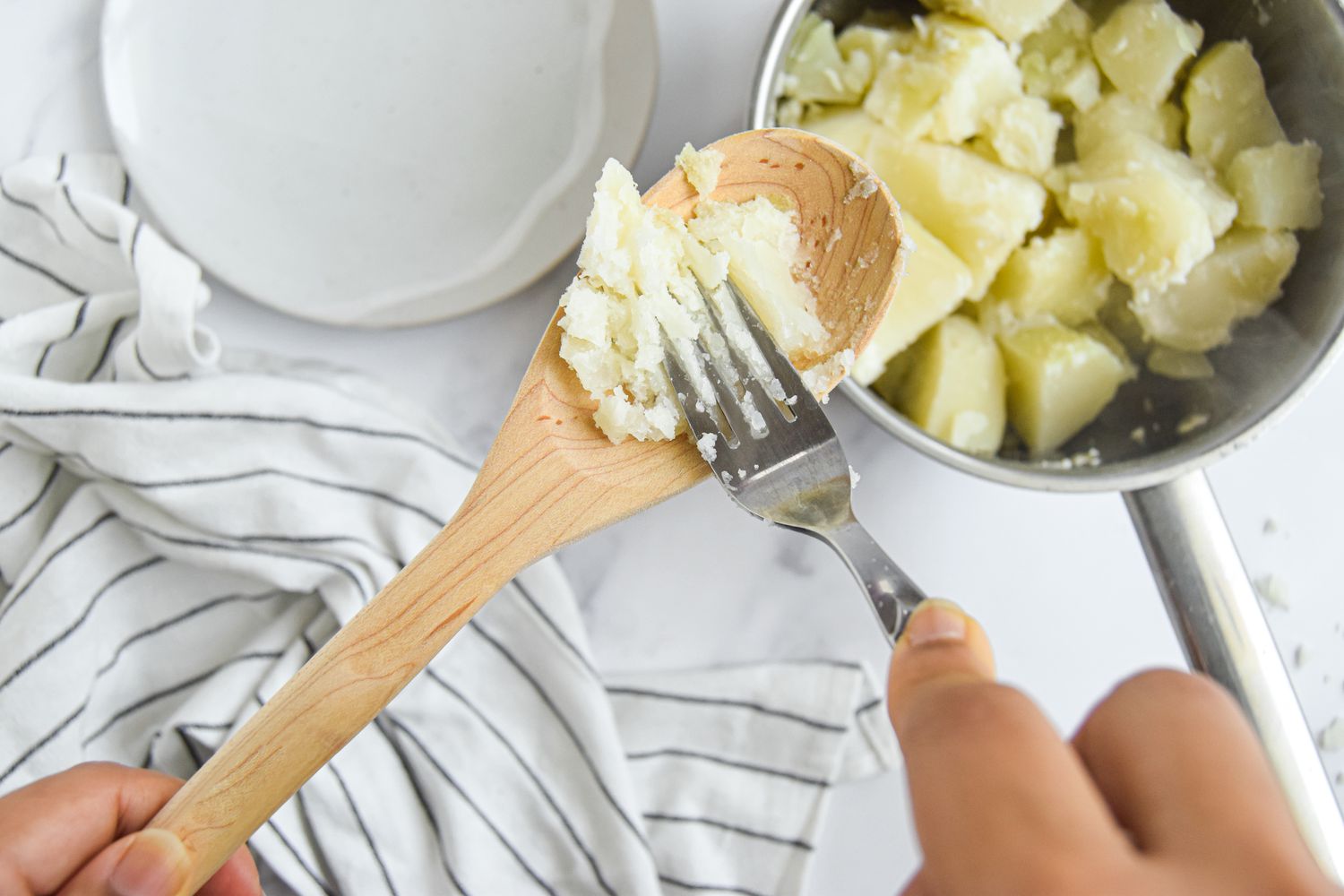 Fork Used to Check If Potatoes Are Fork Tender for Mashed Potatoes Recipe