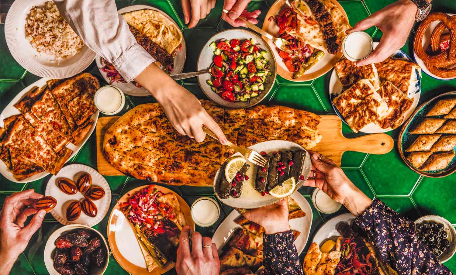family enjoying middle eastern food (dolma, kebabs, flatbread) for iftart, Ramadan