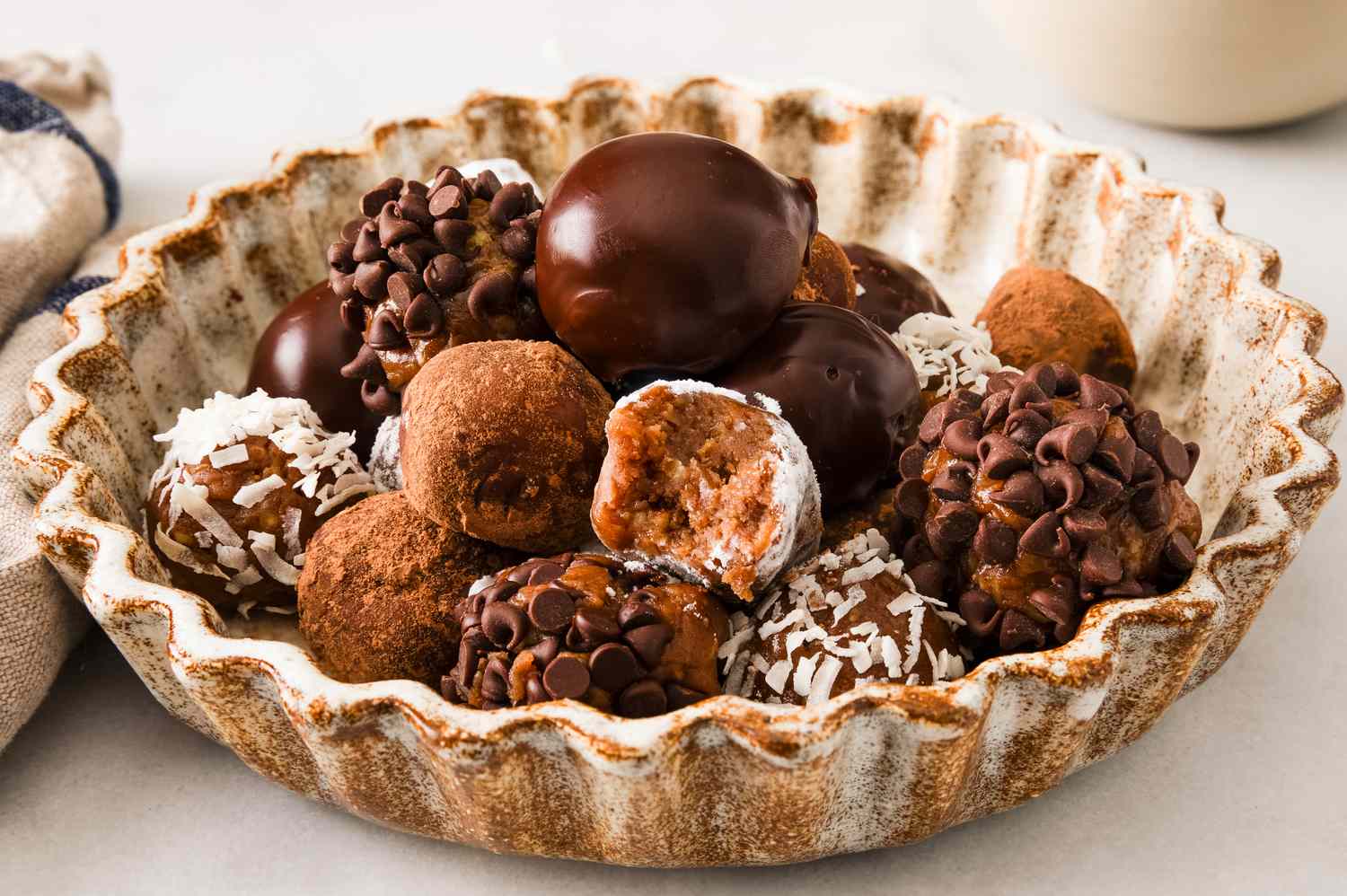 Side view of a bowl of rum balls from Granny's Rum Balls recipe with various coatings