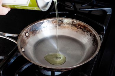 Pouring grapeseed oil into a skillet 