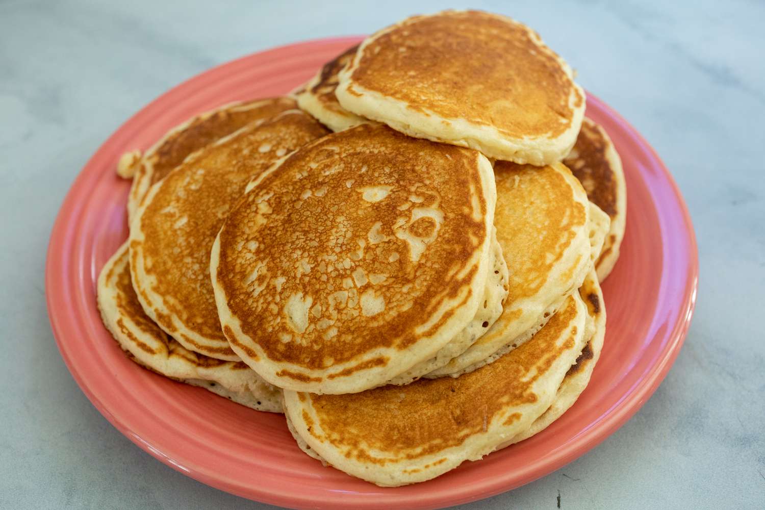 A pile of pancakes on a red plate