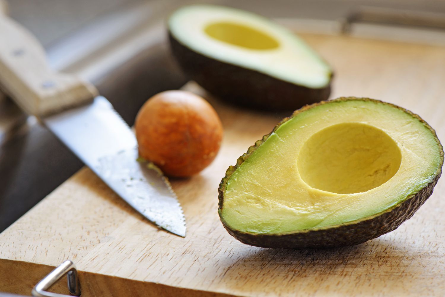 Halved avocados on a cutting board