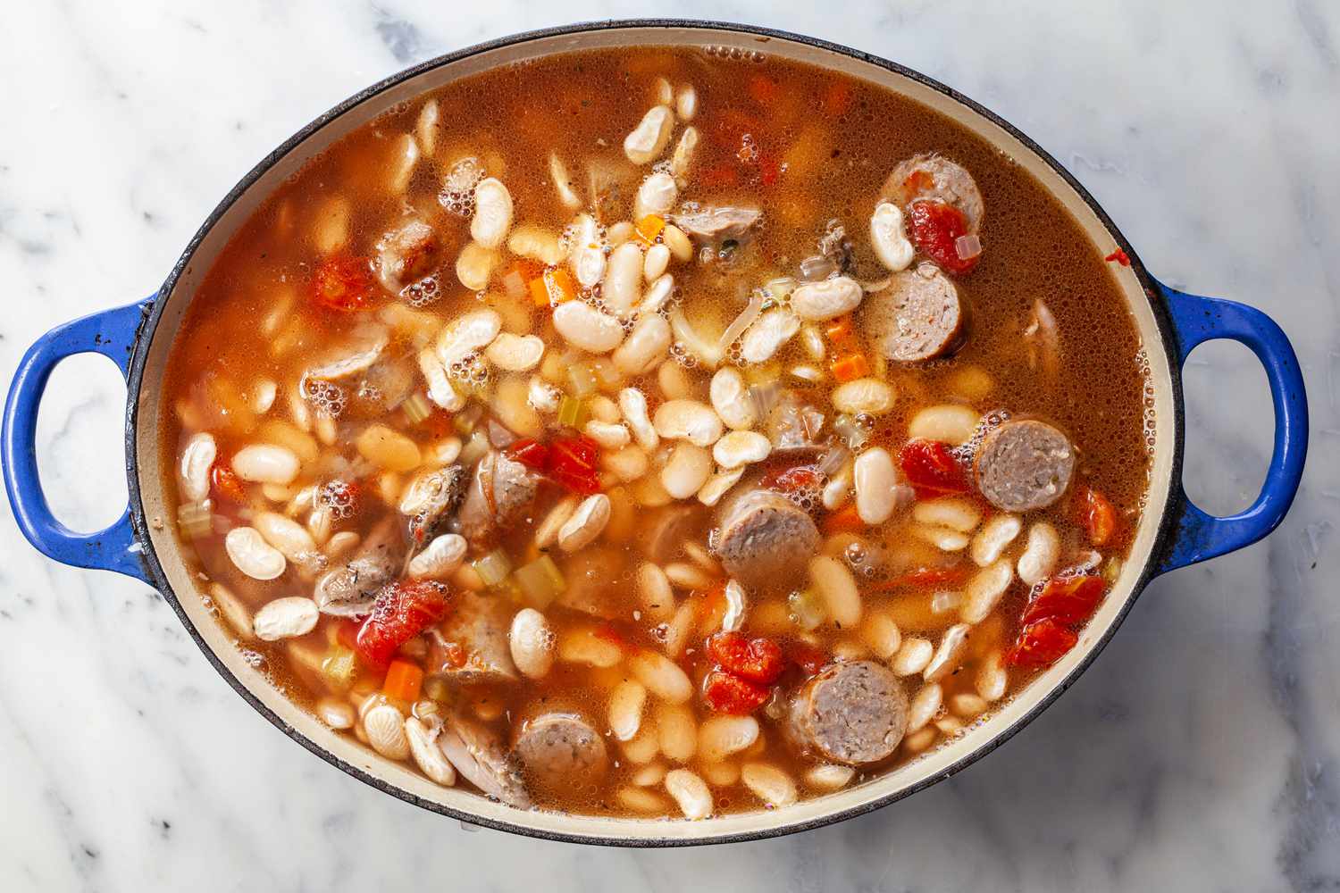 Add final layer of beans and bean liquid in Dutch oven.