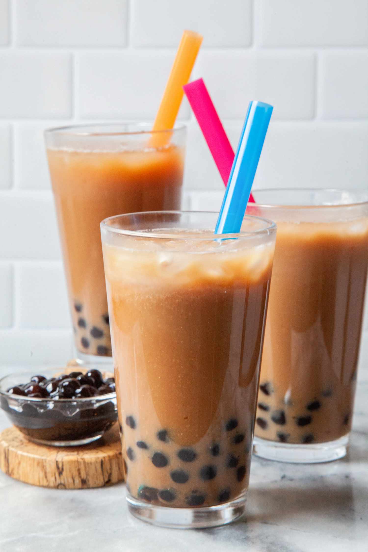 Three Glasses of Bubble Tea Next to a Bowl of Boba
