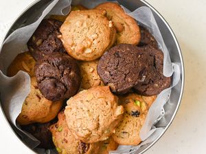 An assortment of cookies in a round tin box