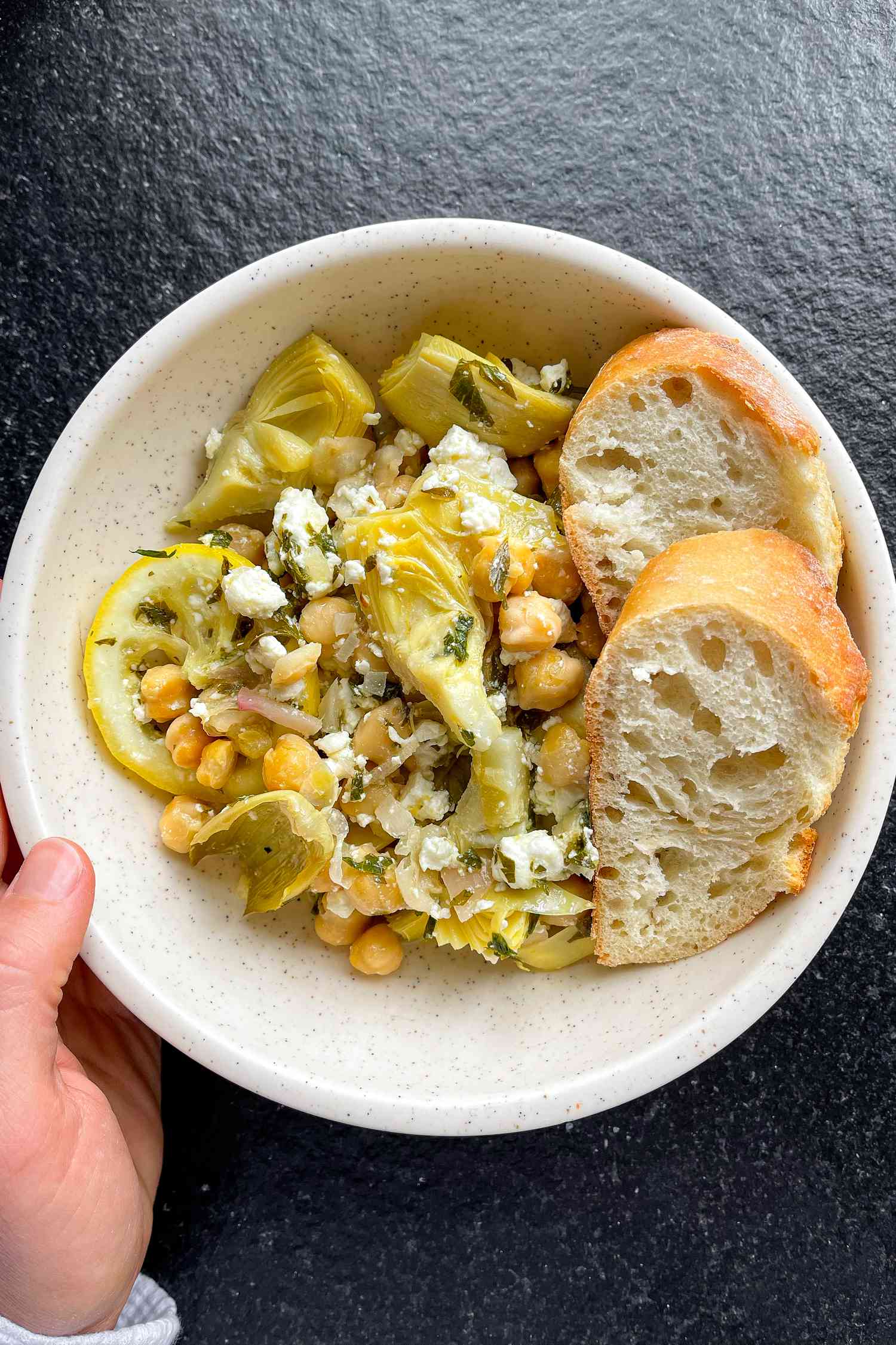 Bowl of roasted chickpeas and artichokes with bread