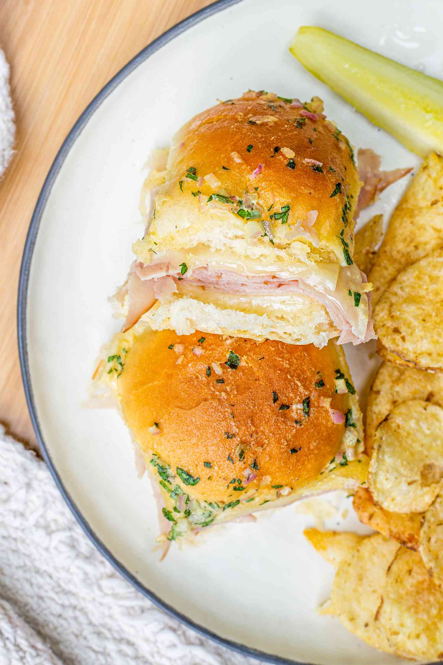 Hot Ham and Cheese Sandwiches on a Plate with Chips and a Pickle