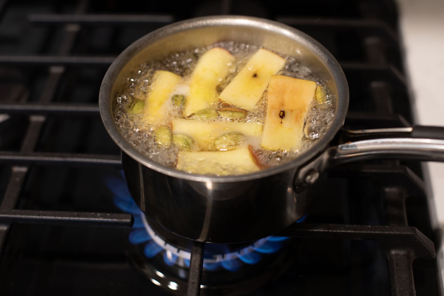 Boiling the apple cores, spices, ginger, and water for simple syrup