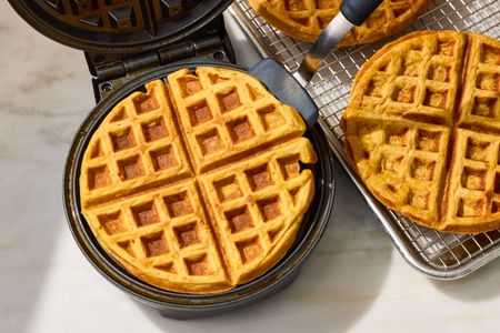 Carrot Cake Waffles in a waffle iron, some on a cooling rack