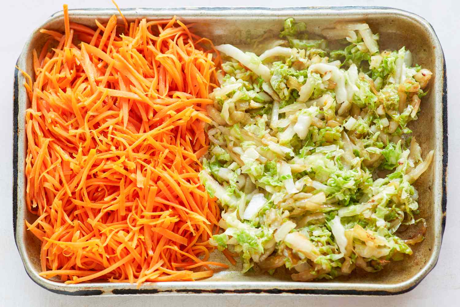 Sheet pans with vegetables to make the filling for spring rolls.