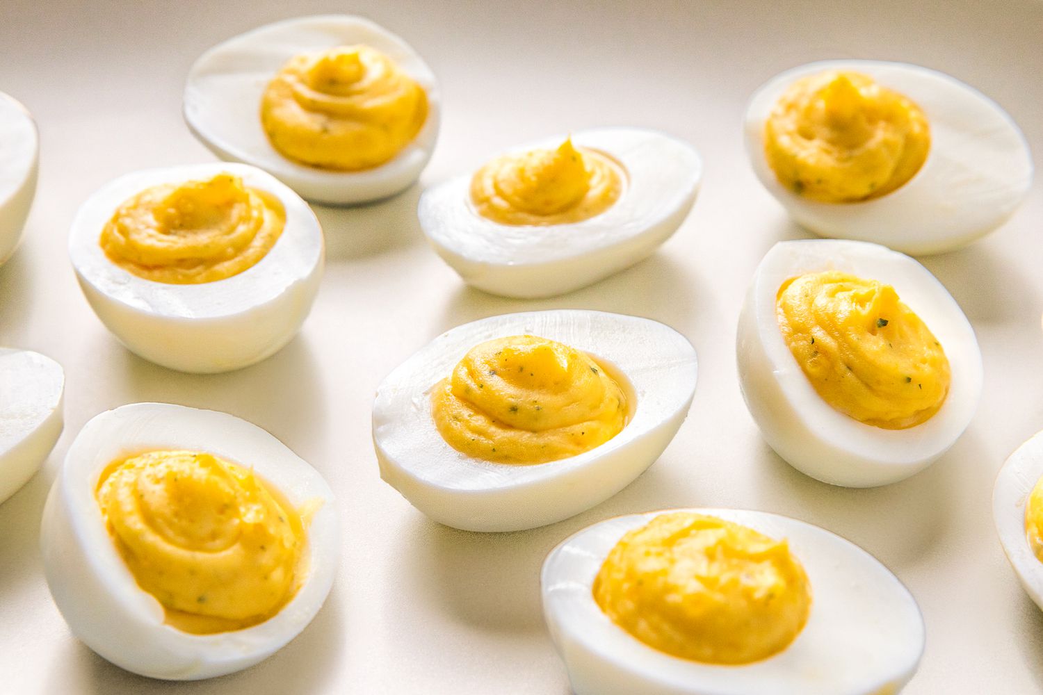 Deviled eggs with creamy filling displayed on a light background
