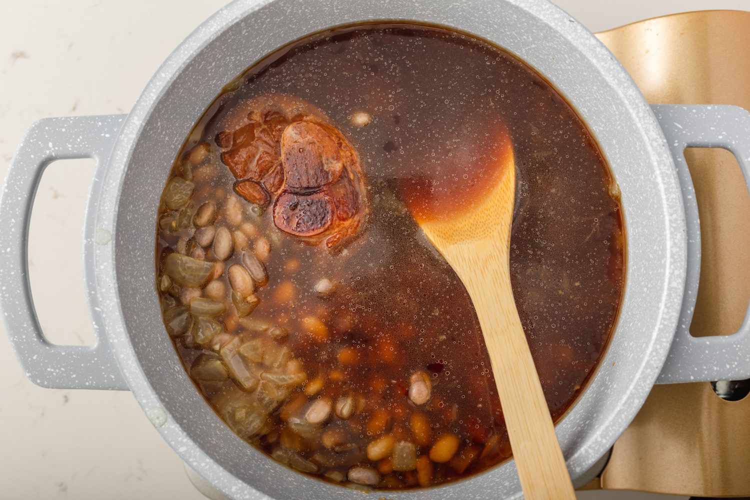 Overhead view of southern pinto beans recipe cooking in a dutch oven.
