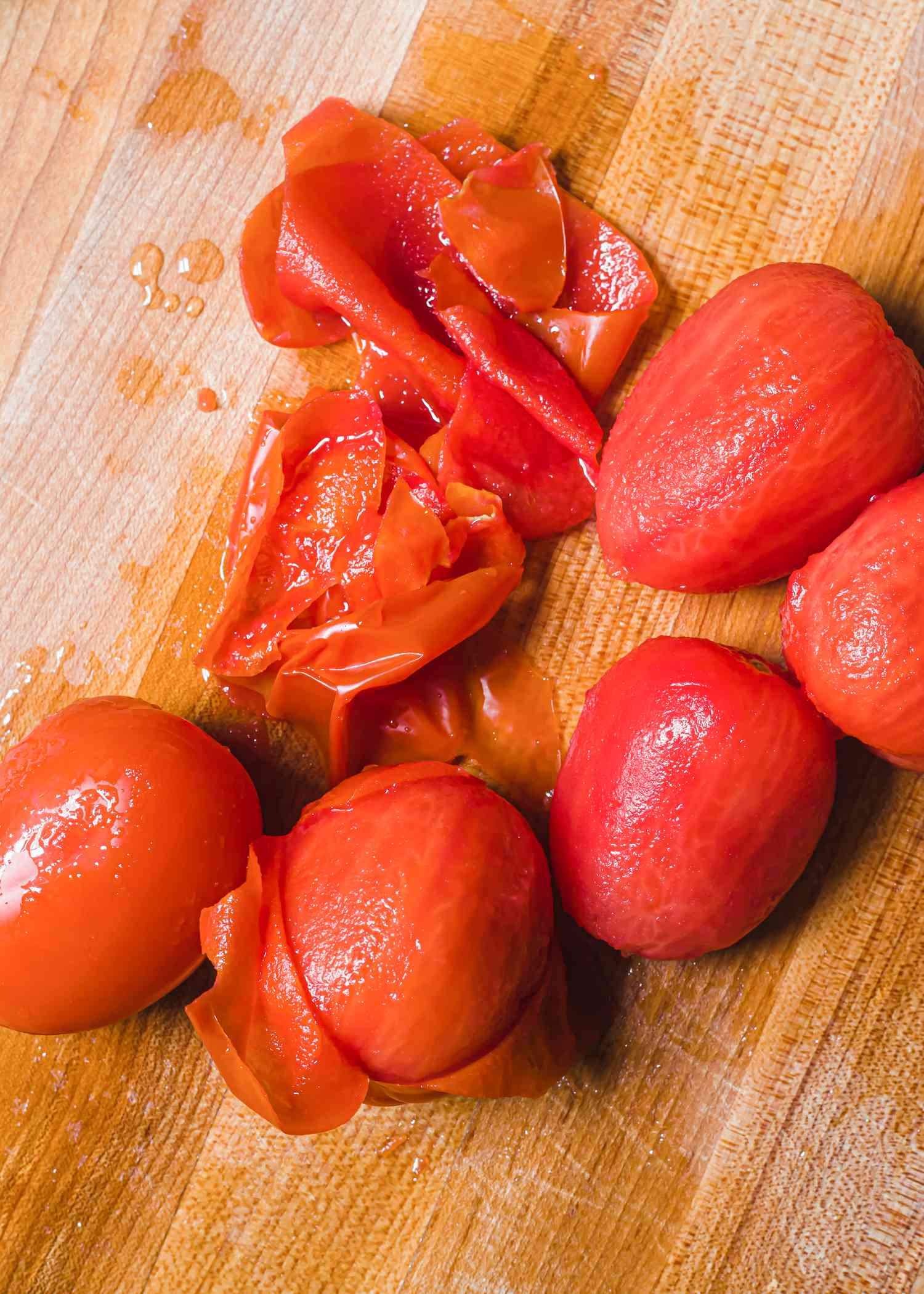 Roma tomatoes with peel on a wood cutting board