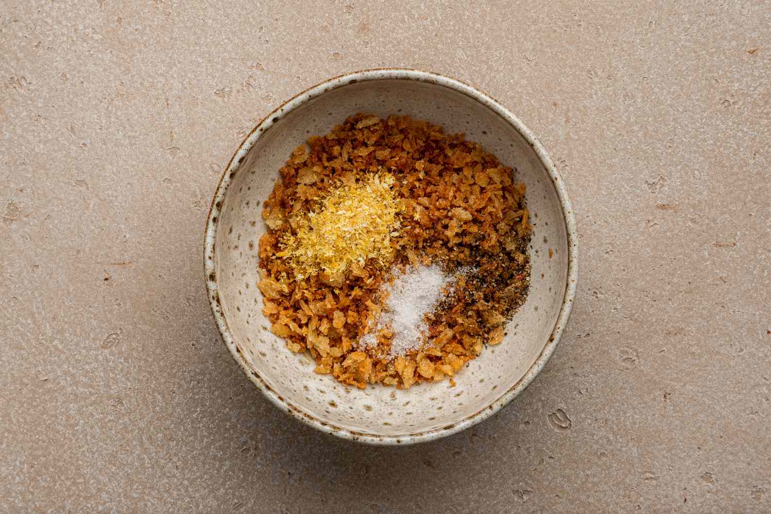 Bowl of Toasted Breadcrumbs, Lemon Zest, and Salt for Brussels Sprouts Caesar Salad with Lemony Breadcrumbs Recipe