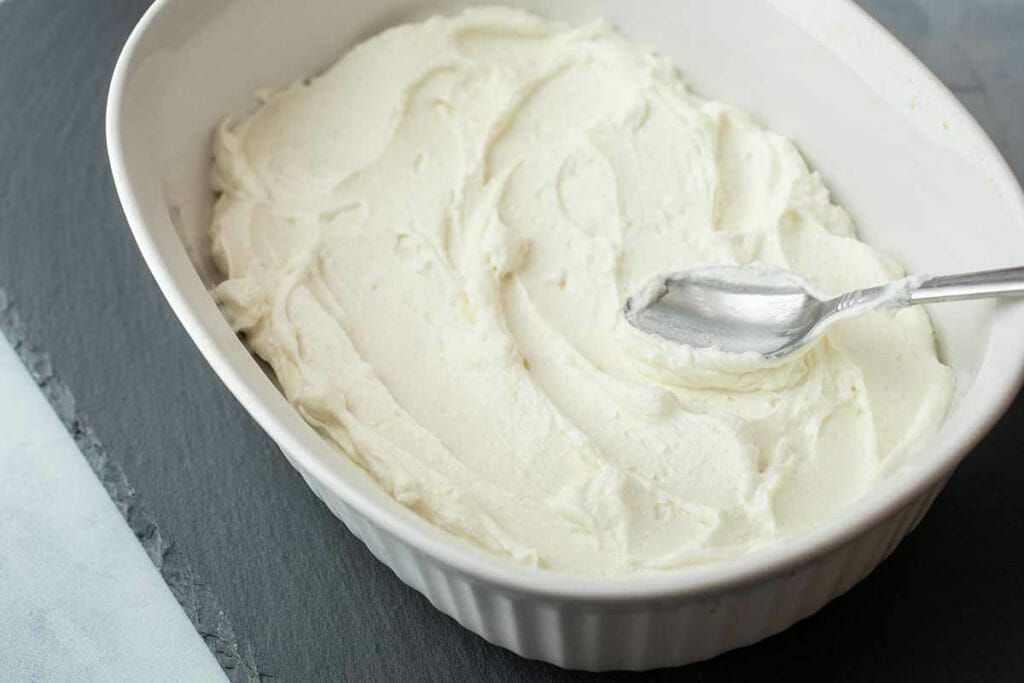 Spread goat cheese in bottom of baking dish for 7-layer dip recipe