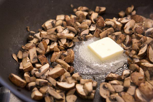 mushrooms with butter being melted in the center of skillet