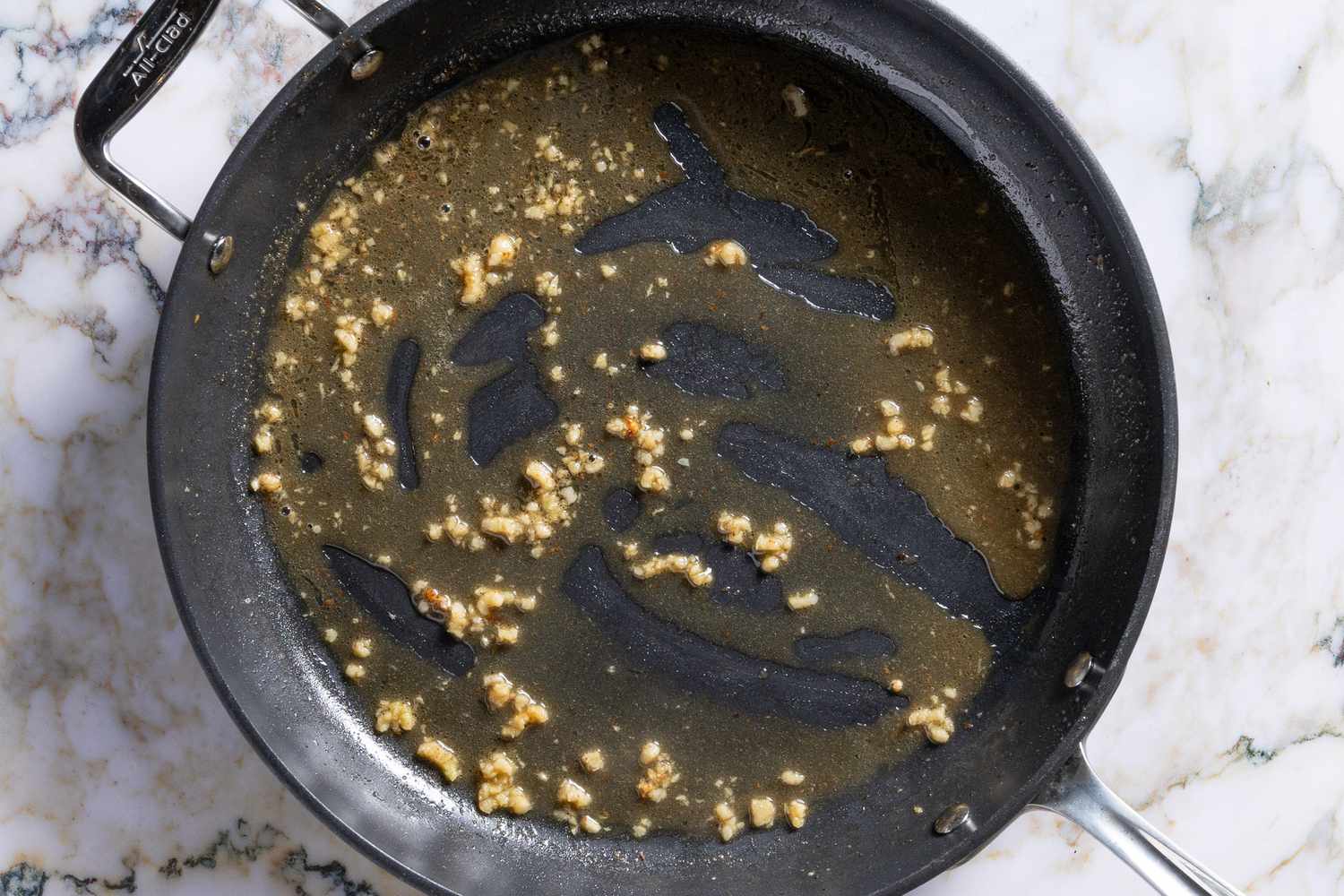 garlic added to butter mixture in skillet for Salmon Piccata