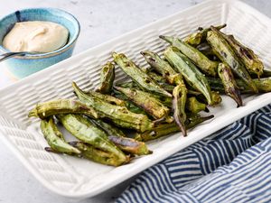 Platter of Grilled Okra Next to a Small Bowl of Sauce 