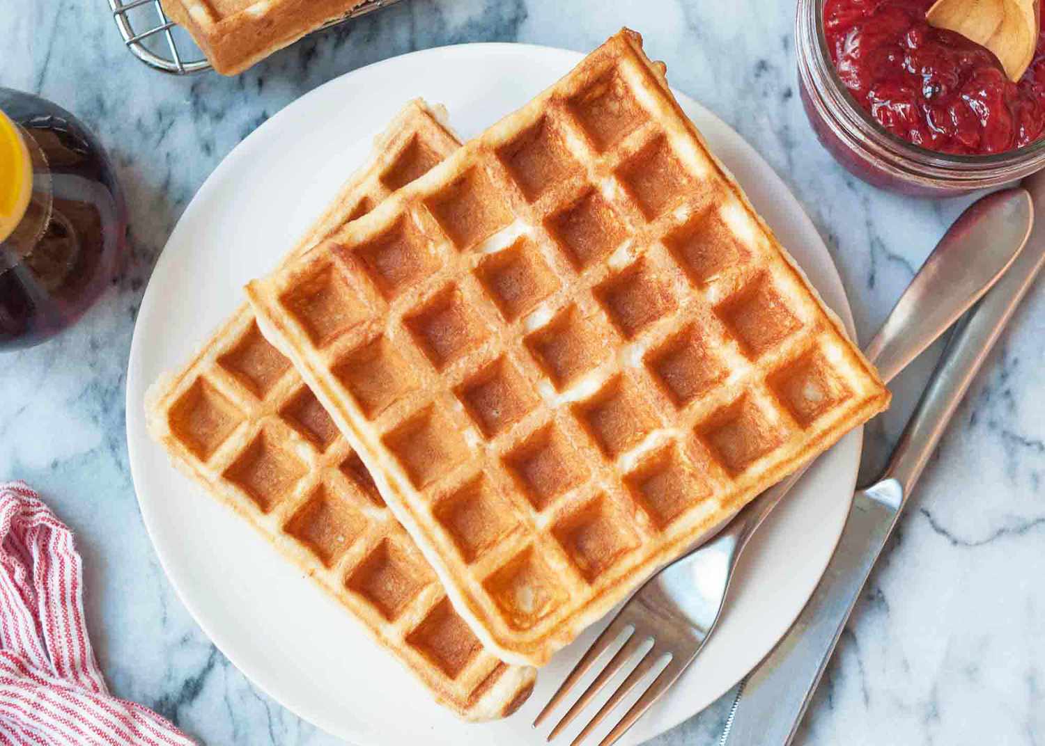 Easy waffle recipe served on a round plate with maple syrup